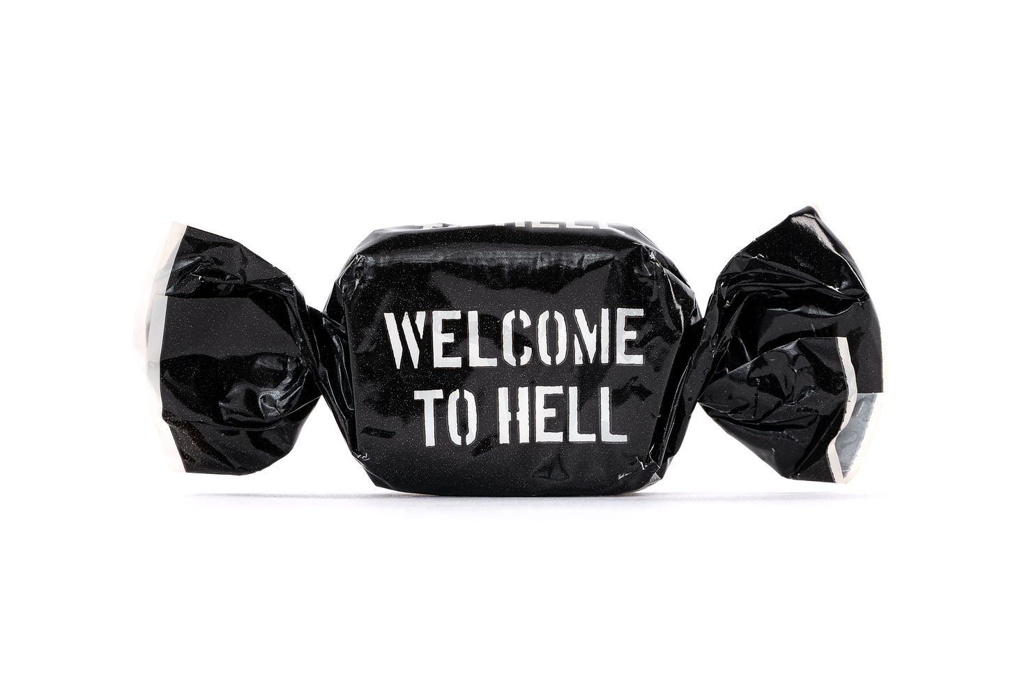 Picture of a wrapped sweet against a white background. The wrapper is black and has the text 'Welcome to Hell' written on it.