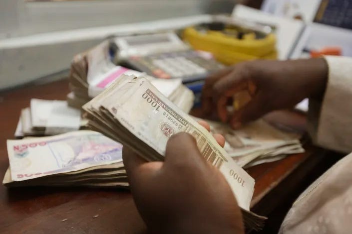 FILE - A money changer counts Nigerian naira currency at a bureau de change, in Lagos Nigeria, Oct. 20, 2015. Nigeria’s central bank has extended the timeline to swap out its old currency for redesigned notes after the change triggered a cash shortage. On Tuesday, March 14, 2023, both old and redesigned notes were still not available for thousands queued at banks in Nigeria’s capital of Abuja. (AP Photo/Sunday Alamba, File)
