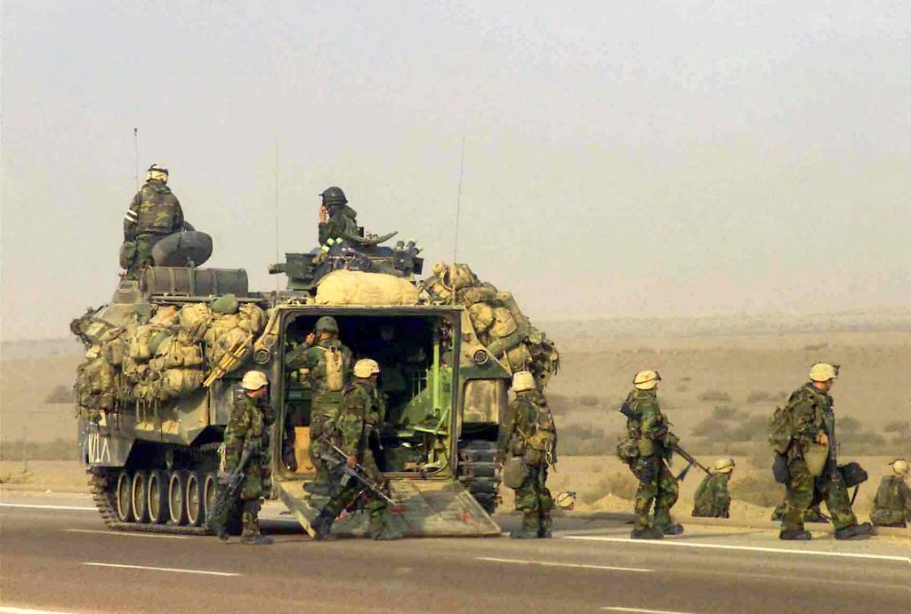 US Marine Corps (USMC) Marines assigned to 1ST Marine Regiment use an  Amphibious Assault Vehicle (AAV7A1) to stage defensive positions along the  highway on a march to the Euphrates River, in Iraq