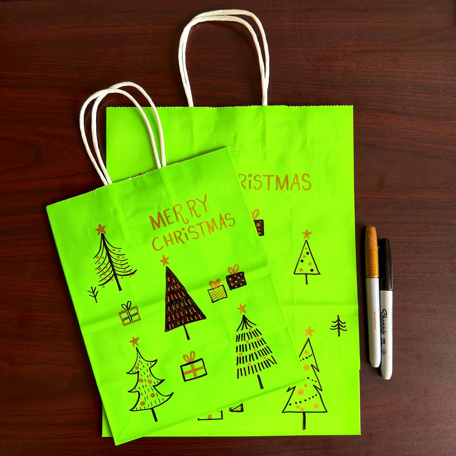 Gift bags with hand-drawn Christmas trees on them.