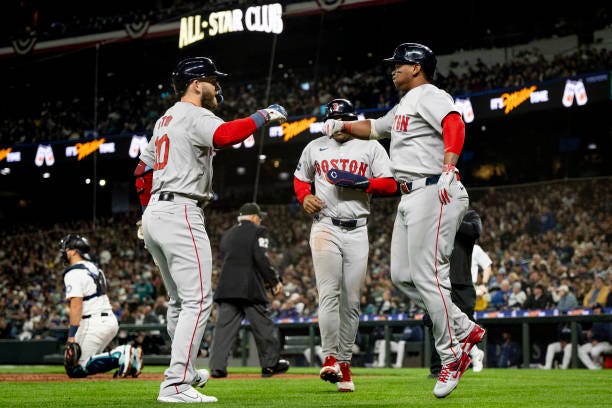 Rafael Devers of the Boston Red Sox reacts with Trevor Story of the Boston Red Sox after hitting a two-run home run during the third inning of the...