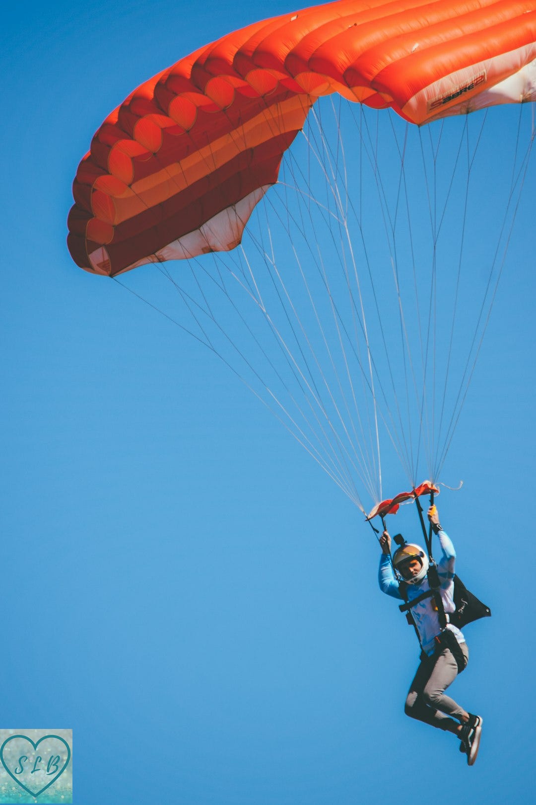 a man flying through the air while holding onto a parachute