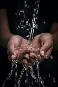 A stream of water splashing into cupped hands