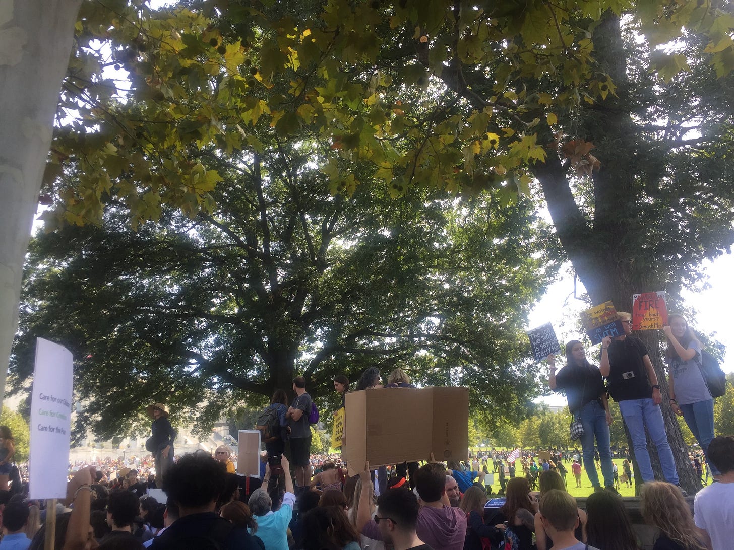 A crowd of students holding up signs while protesting on the Capital lawn