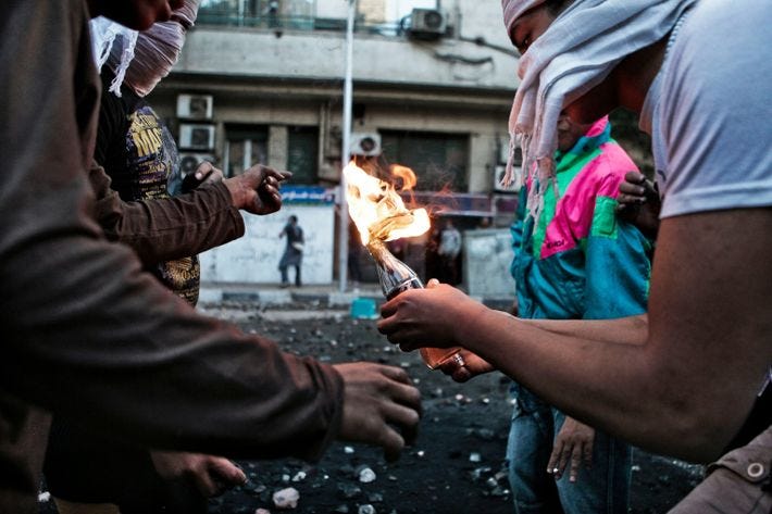 Protestors prepare to throw a Molotov cocktail toward police during clashes in 2012 near Tahrir Square ...