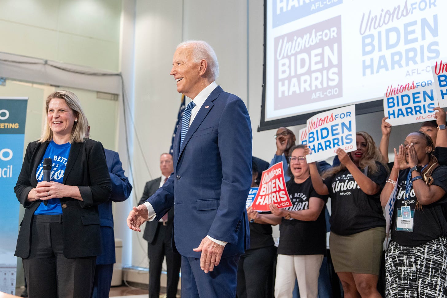 President Joe Biden delivering remarks at a meeting of national union leaders at the AFL-CIO Headquarters. Behind him are people holding up signs that read: "Unions for Biden Harris"