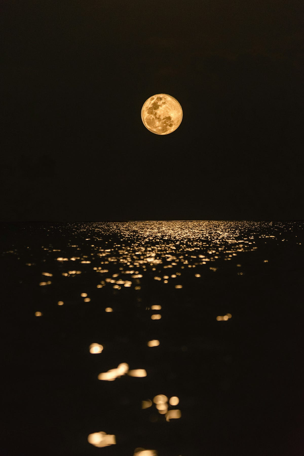 Moon reflected on the water at night.
