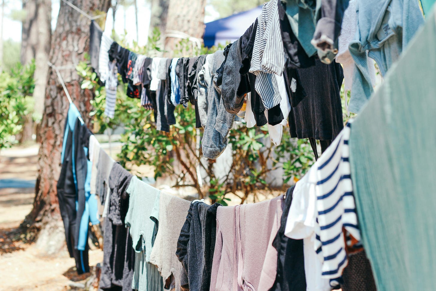 very full clothesline with lots of wet clothes in sun