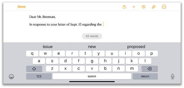 An iPhone screen in horizontal mode, with a gray-and-white keyboard taking up the lower half of the screen and a typed letter being composed above it, which reads, “Dear Mr. Brennan, In response to your letter of Sept. 15 regarding the”