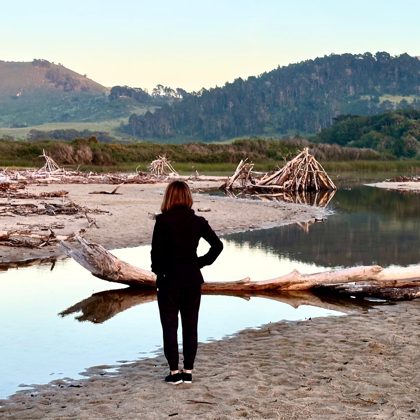 Driftwood teepees at Carmel River State Beach as the river breaches to the ocean
