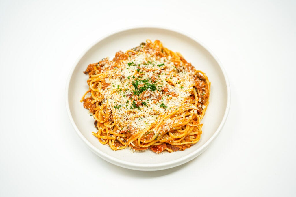 Creamy Mezcal, Bacon & Roasted Tomato Linguine served on a plate, featuring tender linguine coated in a rich, smoky mezcal cream sauce, topped with crispy bacon and sweet roasted tomatoes for a flavorful, indulgent pasta dish.