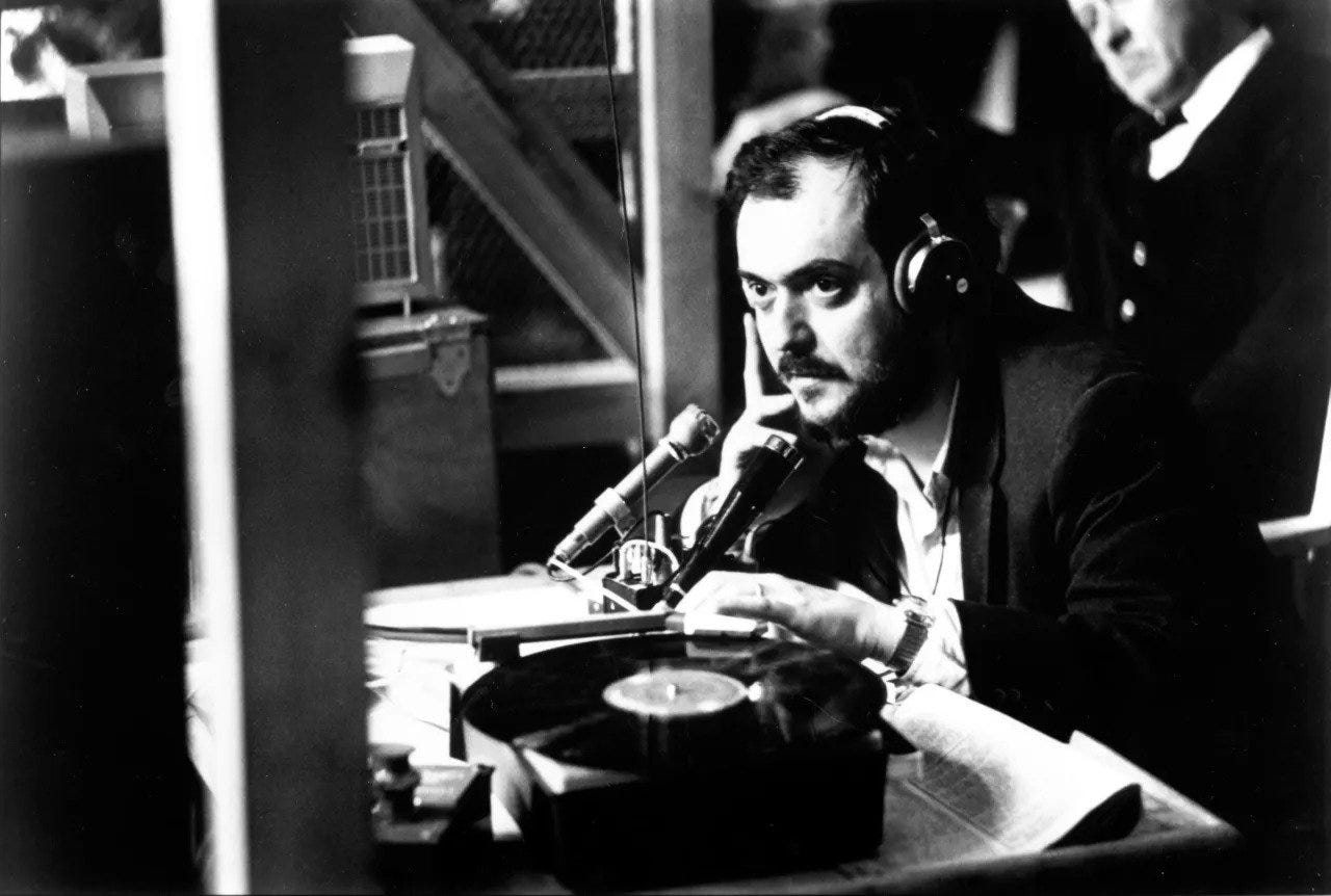 Stanley Kubrick wearing headphones on set and looking intense.