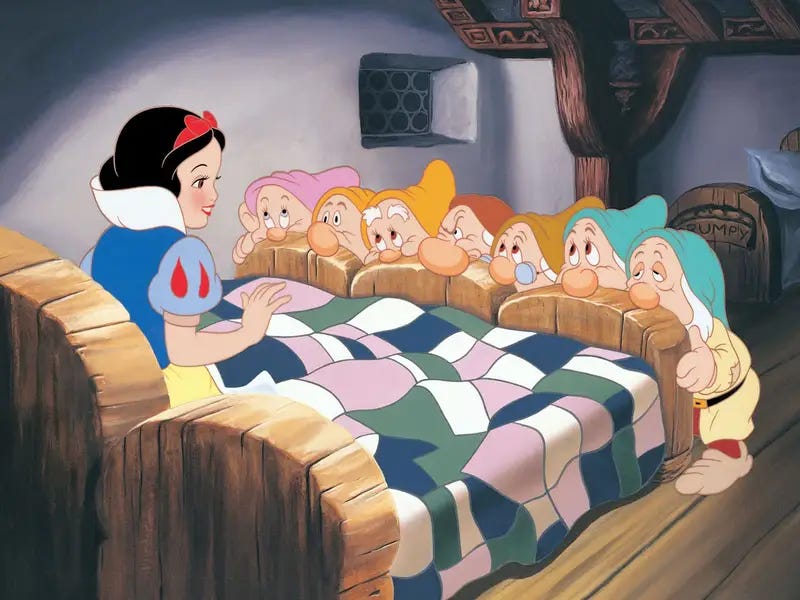 Snow White is in bed as the Seven Dwarves are standing in front of the bed. There noses are draped over the beds.