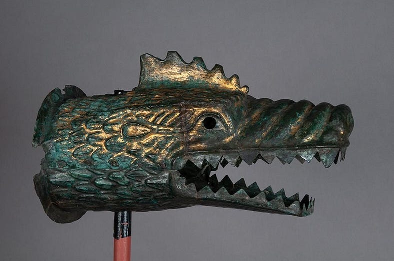 Ornamental green and gold dragon’s head with open wide mouth. It has very sharp pointy teeth and a long nose, very crocodile-like, plus a gold ornamental ridge on its head, like a Cockerel. Ready to be put on a stick and terrify the enemy with wind-whistled noise!