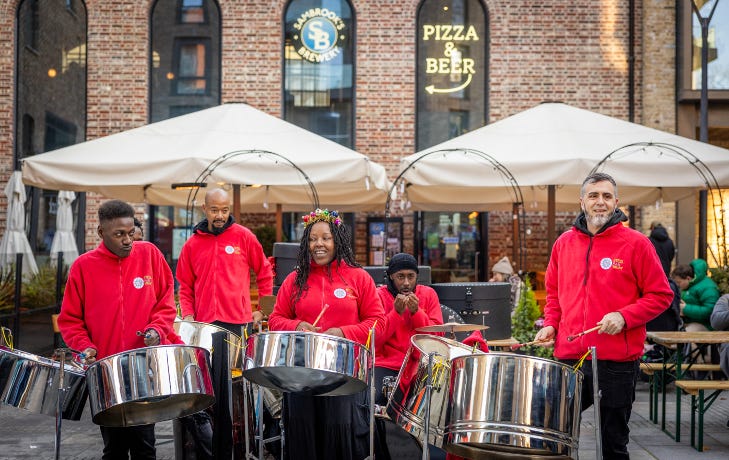 A steel pan drumming group performing in an open-air square