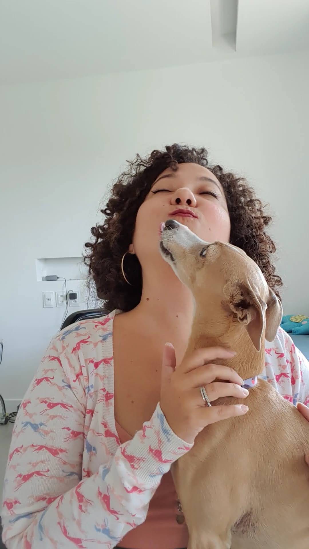 Ravi tenta me beijar, tem a lingua meio pra fora enquanto eu jogo minha cabeça pra trás fazedo biquinho e abraço ele. visto um casaco com estampa de galgos