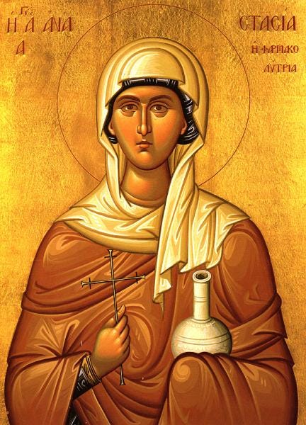 In this modern Greek icon of St. Anastasia, she is holding a cross in her right hand and a large, white medicinal vial in her left with a white towel. The inscription in Greek reads (Left side:) "St Ana-" (Right side:) "-Stasia Deliverer from Poisons" In this modern Greek icon of St. Anastasia, she is holding a cross in her right hand and a large, white medicinal vial in her left with a white towel. The inscription in Greek reads (Left side:) "St Ana-" (Right side:) "-Stasia Deliverer from Poisons"
