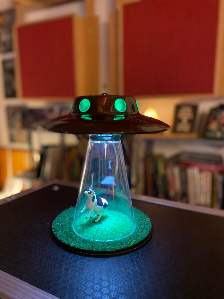 A cow being abducted by a UFO lamp