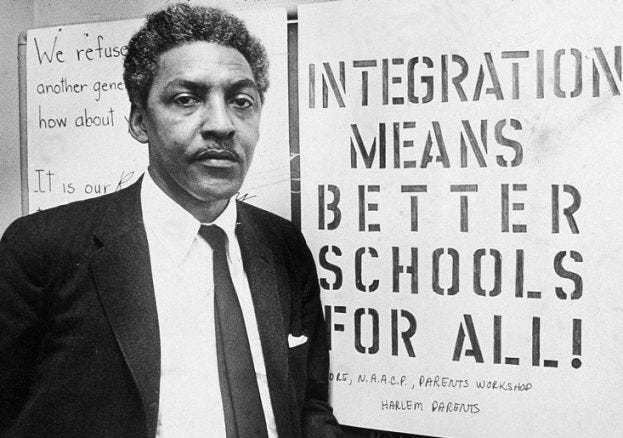 Bayard Rustin in front of an integration poster from the NAACP