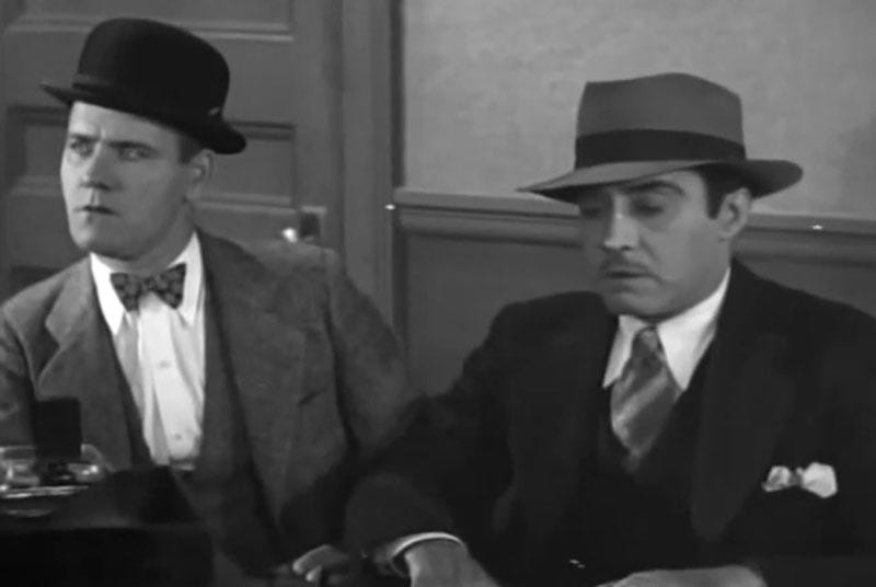 Sam (Tom Dugan) and Collins (Tom McGuire), two of Hawk Miller’s henchmen, sitting in the bootlegger’s office, consider the boss’s instruction to kill Eddie. They don’t look happy.