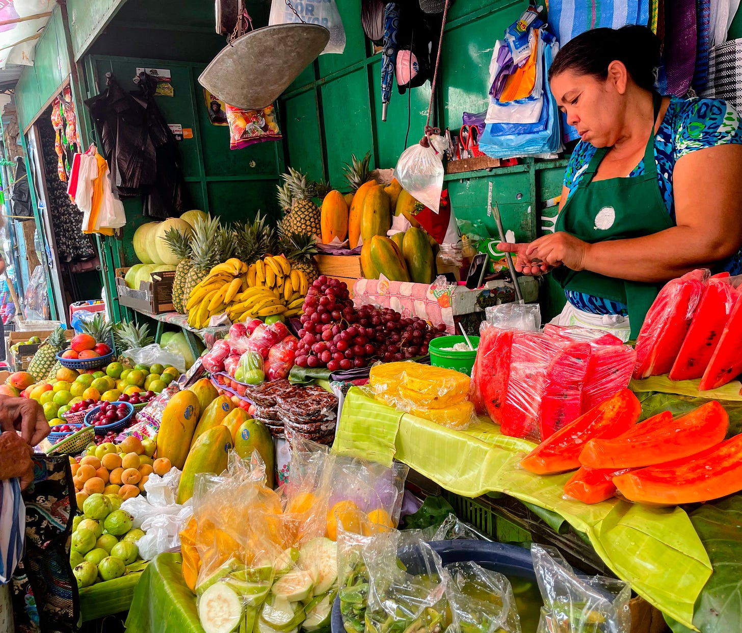 A woman selling fruit counts change