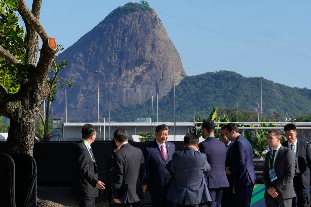 With Rio’s Sugar Loaf mountain in the background, China’s Xi Jinping (centre) mingles with other leaders and diplomats at the G20 summit on Monday. Photo: AP