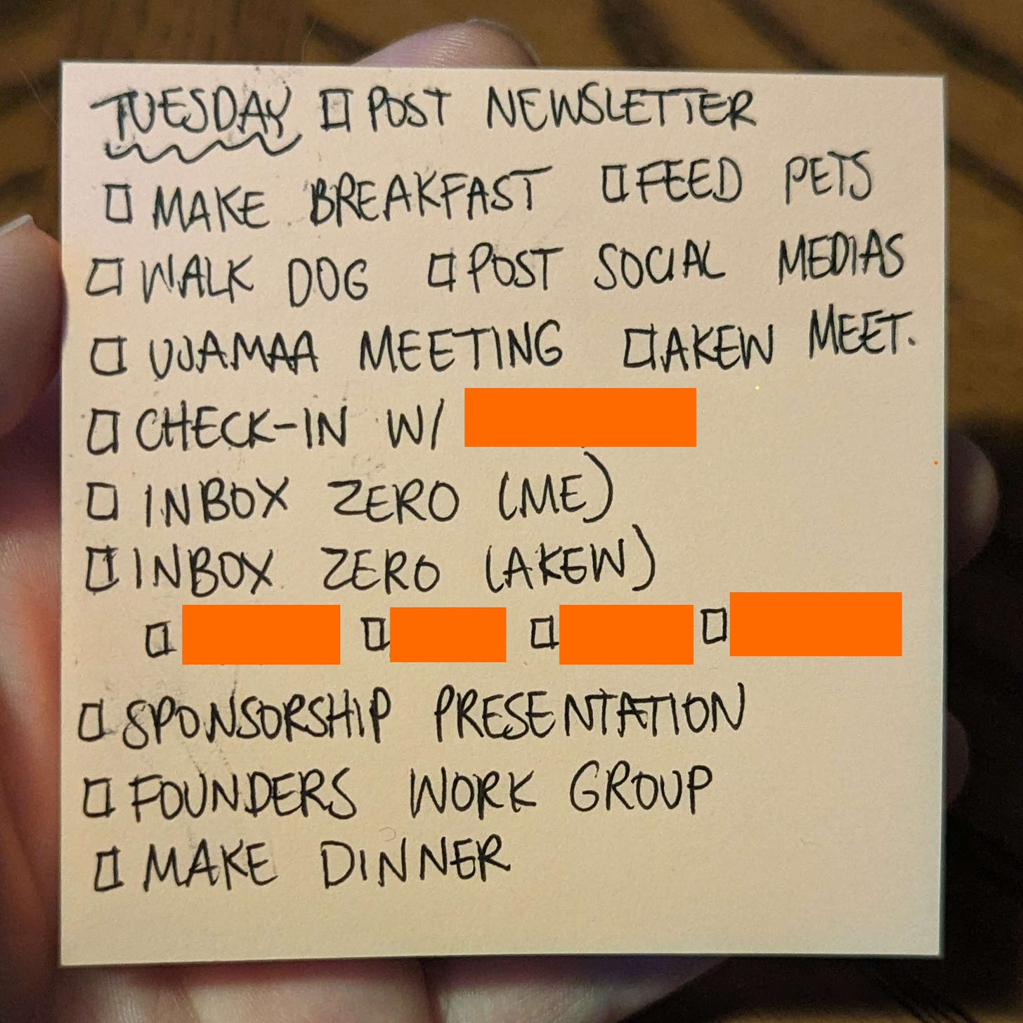 A sticky note with "Tuesday" written on top and a task list featuring items like "Make Breakfast" and "Inbox Zero" on it. There are orange boxes censoring names.