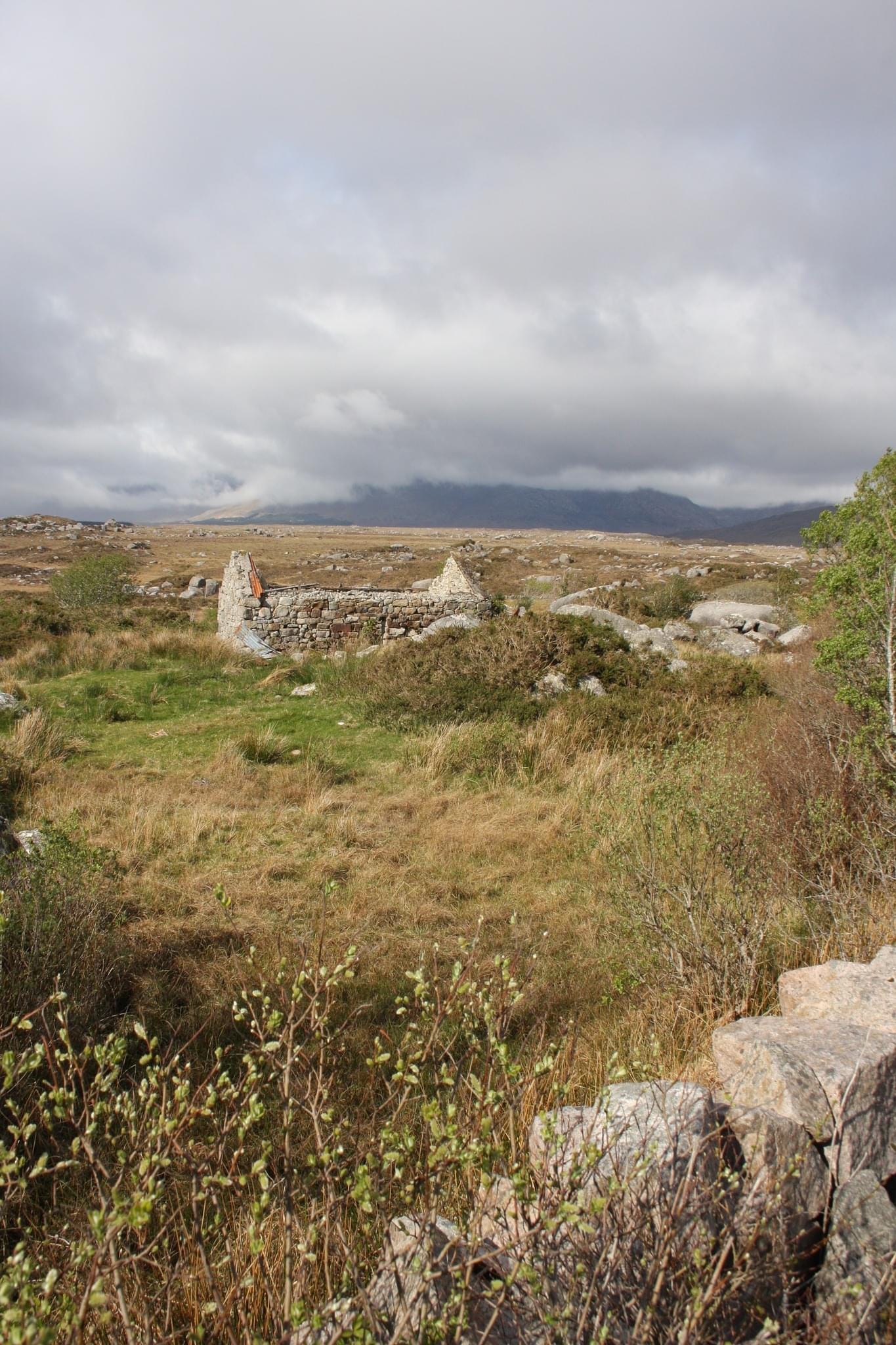 A dilapidated stone cottage with no roof in the middle of stony landscape 