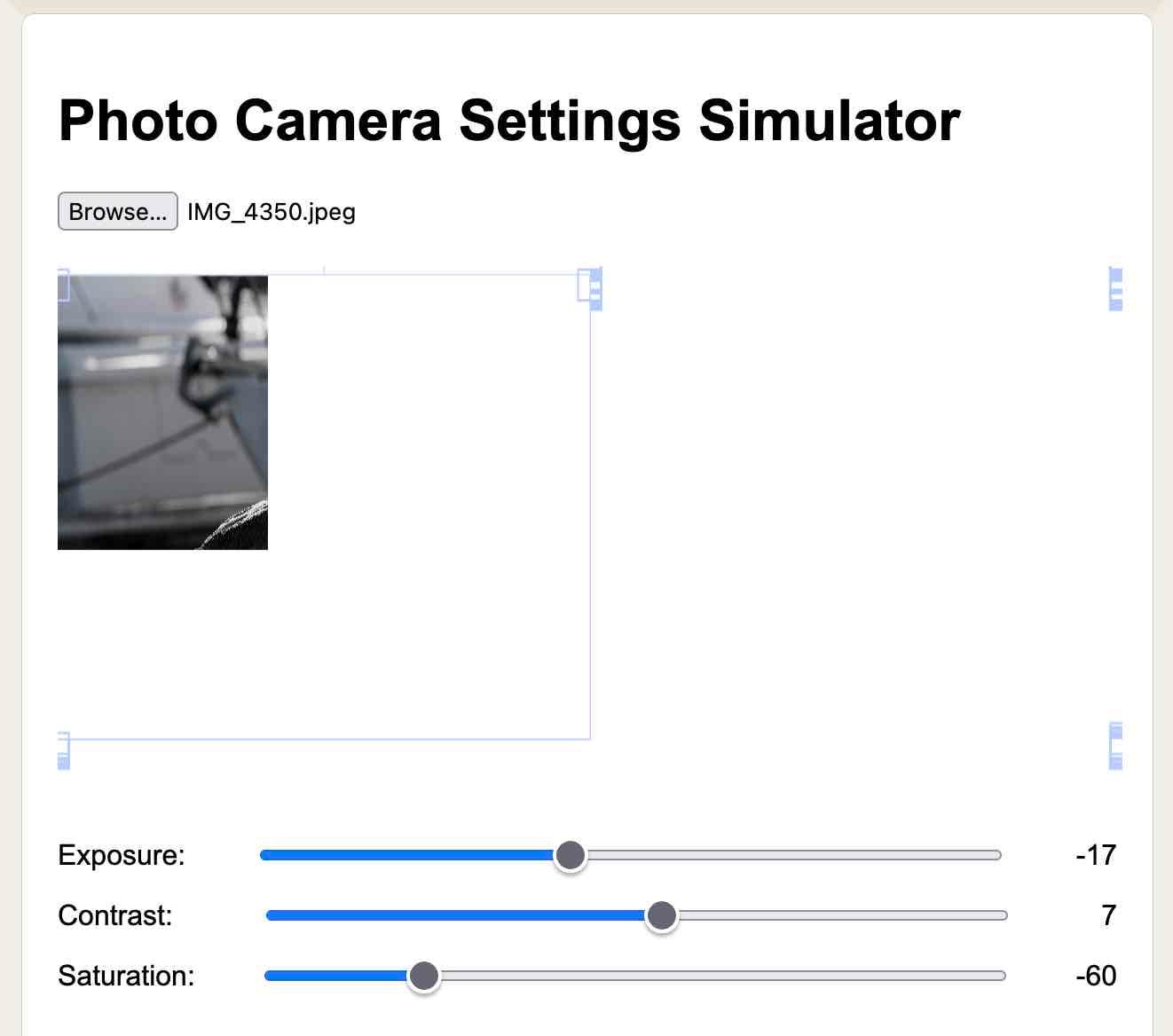 Photo Camera Settings Simulator. An image has been selected - but only the corner of the image displays with some buggy broken resize handles. Three sliders at the bottom show Exposure, Contrast and SAturation.