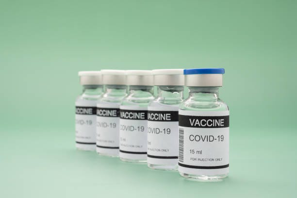 the covid-19 vaccine on a green background. - covid vaccine bildbanksfoton och bilder