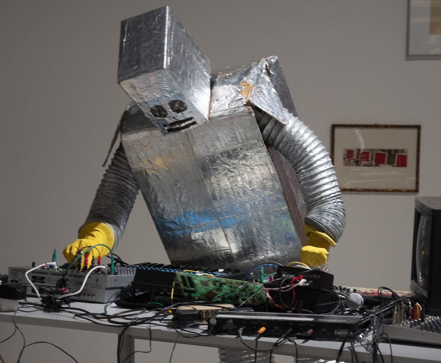 A person in a foil robot costume messing around on a switchboard.