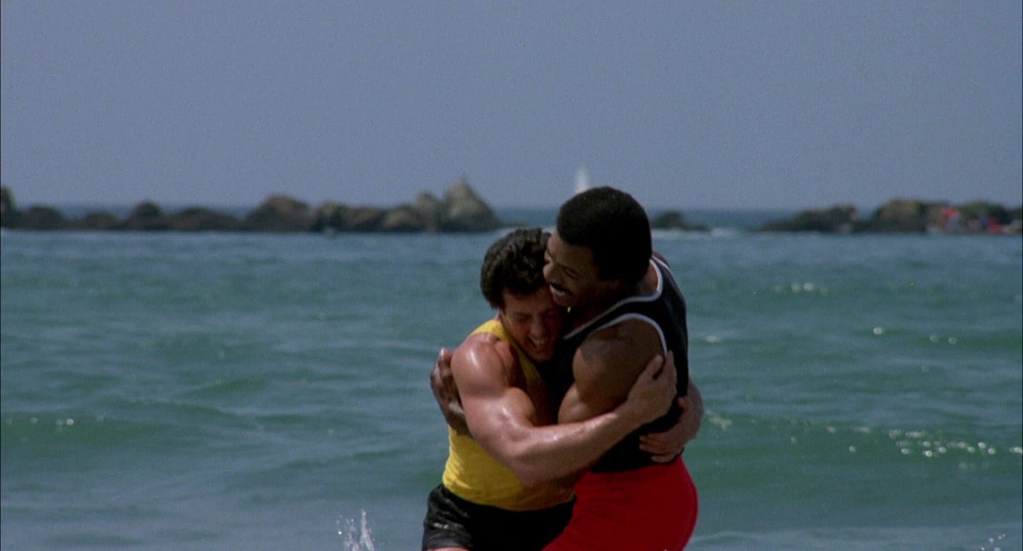 A person hugging another person in the ocean

Description automatically generated