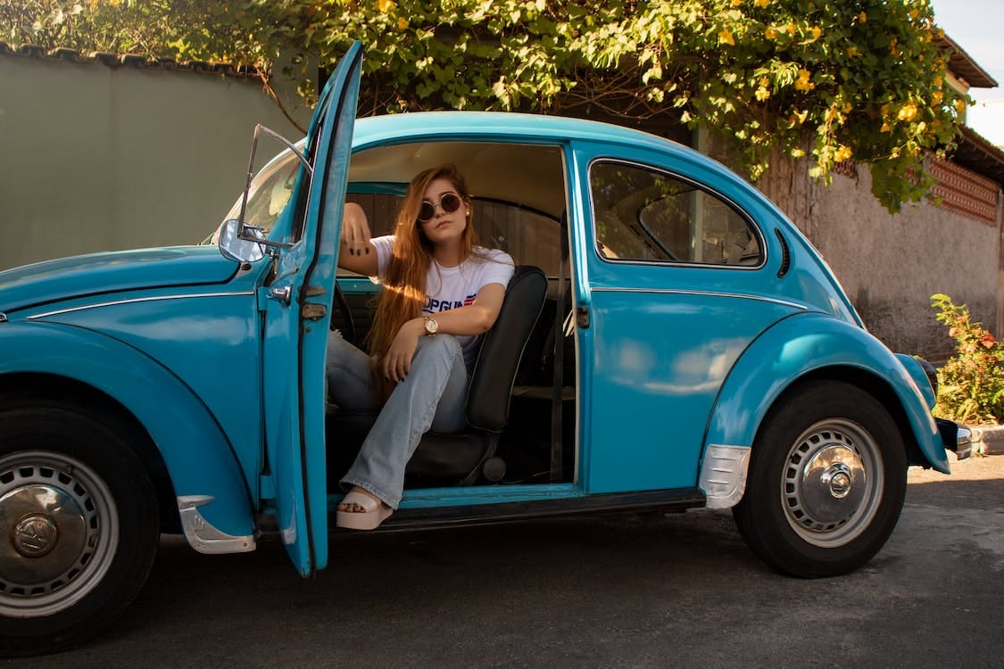 Free Woman Wearing White Shirt Sitting Inside Blue Volkswagen Beetle Stock Photo