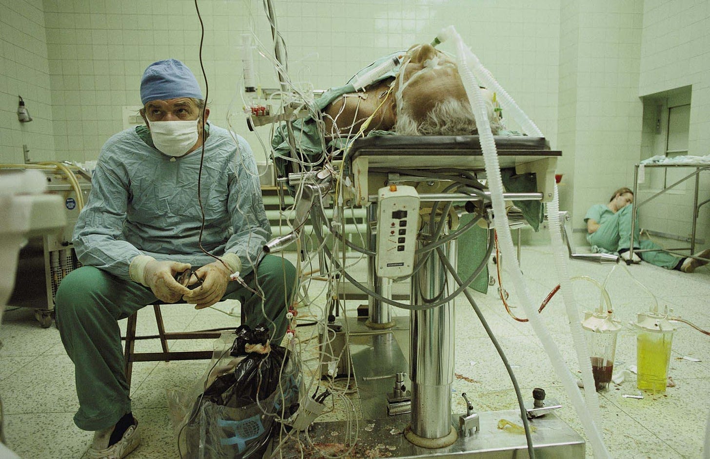 Dr. Zbigniew Religa monitors his patient’s vitals after a 23 hour long heart transplant surgery. His assistant is asleep in the corner.