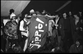 Yippies on stage at the Counter-inaugural Ball, 1969: naked man in an Uncle  Sam hat and comrades unfurl a Yippie! flag - Digital Commonwealth