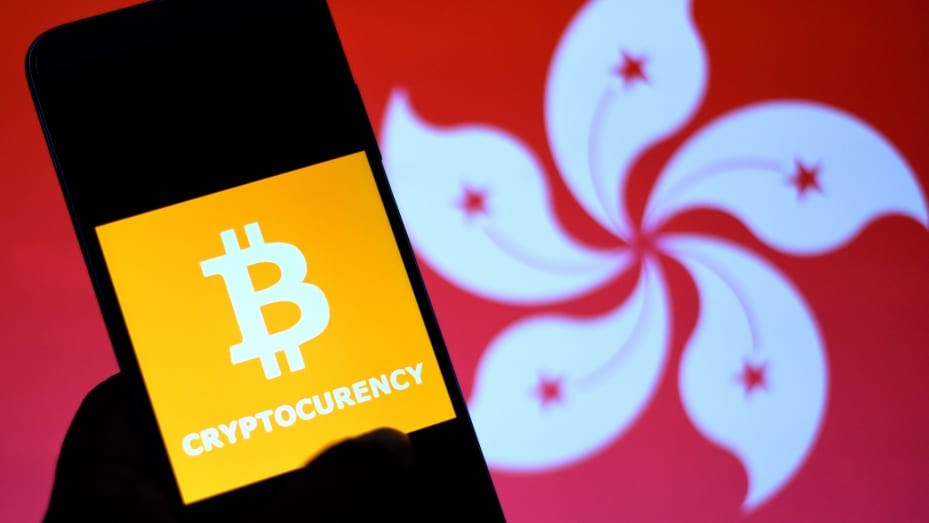 INDIA - 2022/01/15: In this Photo illustration a Bitcoin logo seen on a smartphone with a Hongkong flag in the background. (Photo Illustration by Avishek Das/SOPA Images/LightRocket via Getty Images)