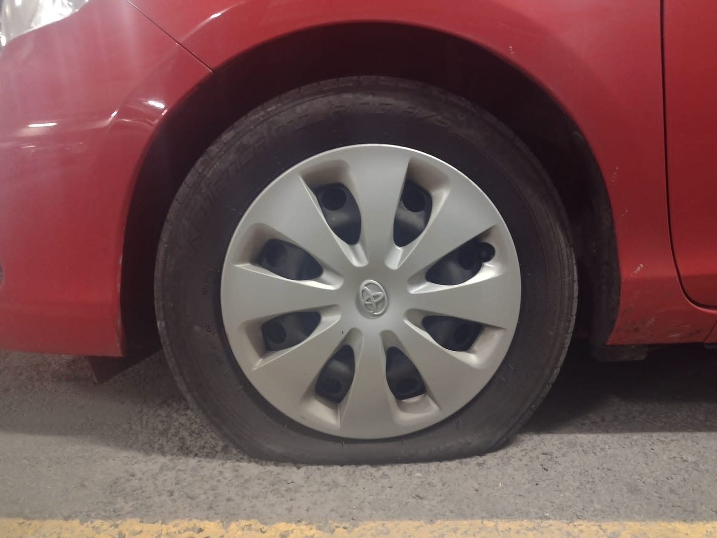 A flat tire on my friend’s red Prius