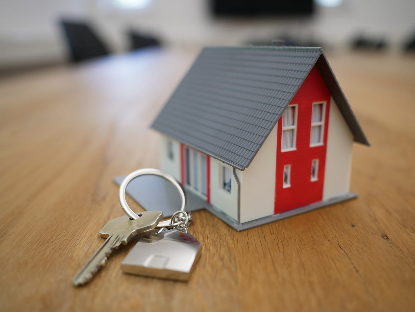 tiny house sitting next to a key on a house keychain