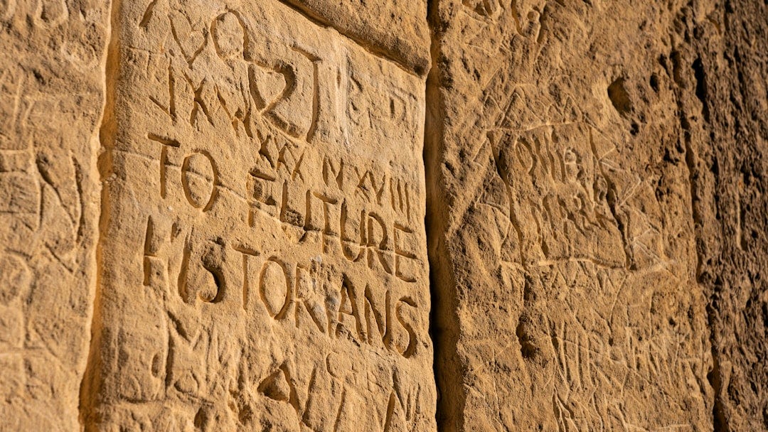 a close up of a stone wall with writing on it