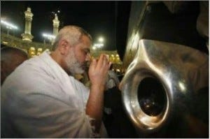 A Hajj pilgrim supplicates and prays before the Black Stone.