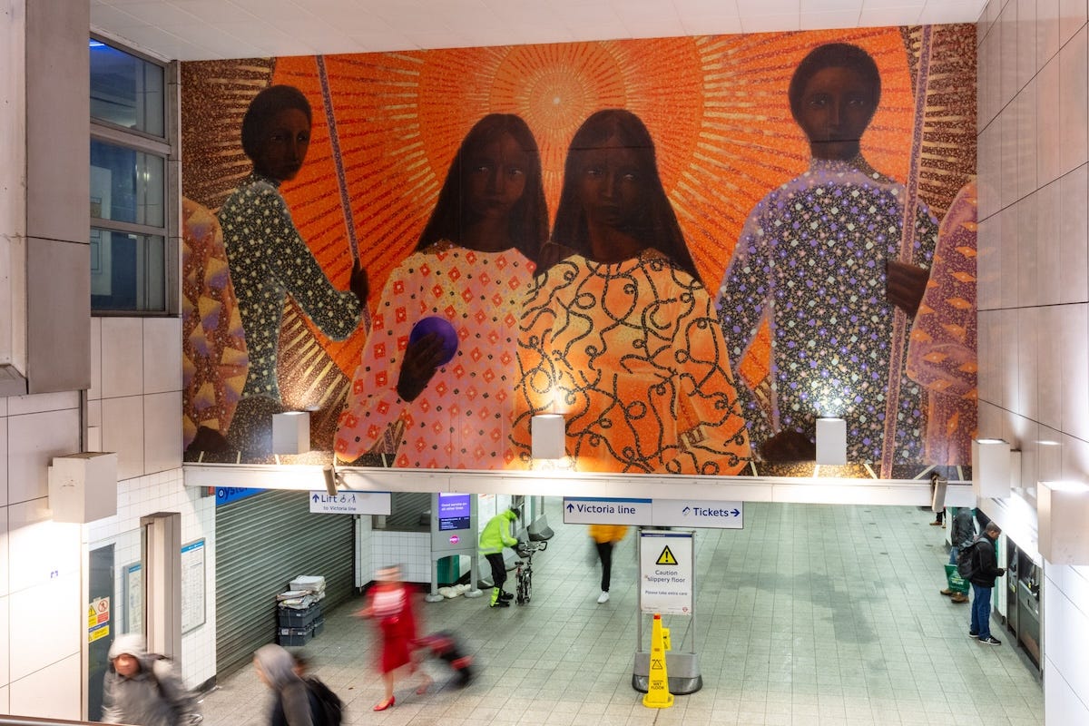 Mural of four stylised Black figures in front of a bright orange halo at the entrance of Brixton tube station.