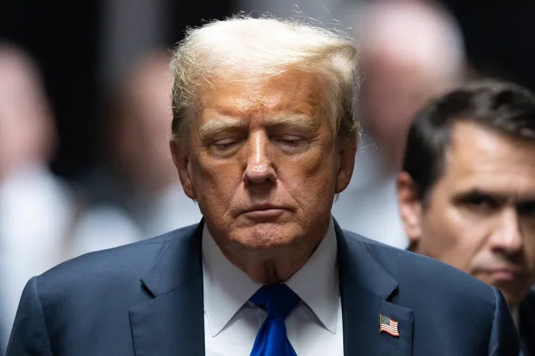 Donald Trump walks outside in Manhattan, with his eyes downcast.
