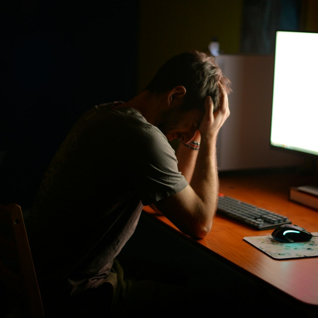 a man sitting at a desk in front of a computer