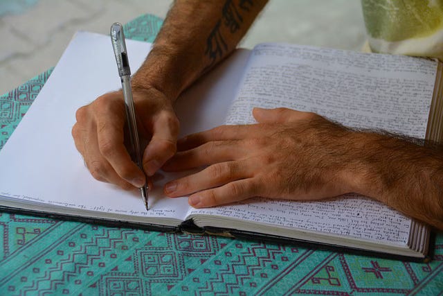 hands writing in journal