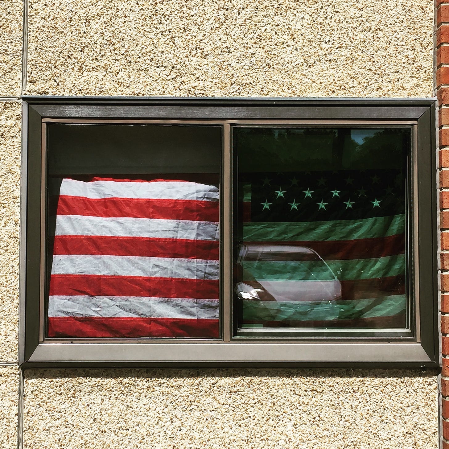 An American flag blocks the sun from entering an apartment.