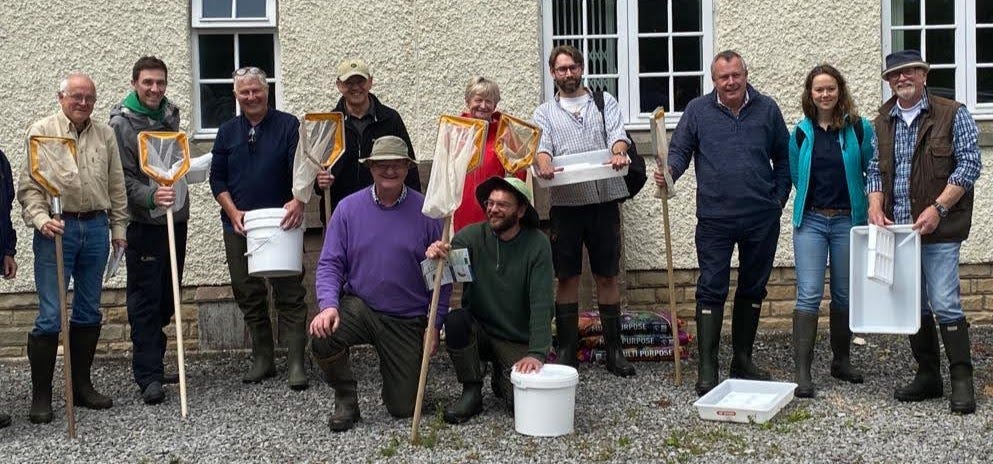 group of people standing with fishing nets and buckets