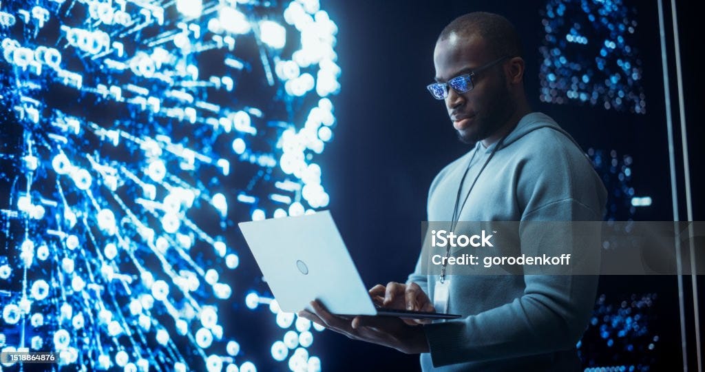 Portrait of Young Black Man Working on Laptop Computer, Looking at Big Digital Screen Displaying Neural Network Visualisation in 3D. Professional Data Specialist Analysing User Information Human Nervous System Stock Photo