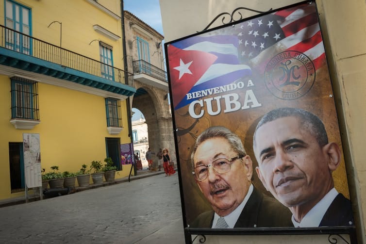 A street sign featuring Barack Obama and Raúl Castro.