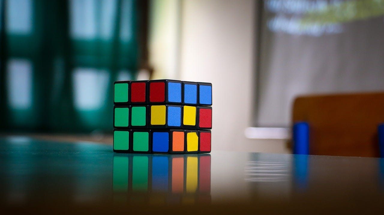 A Rubik's Cube on a table, slightly damaged