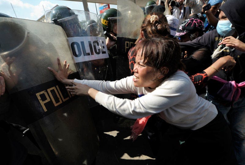 A woman demonstrator pushes back at police as displaced residents of Boeung Lake in Phnom Penh, who were left homeless after the government allowed a private developer to move them out and fill in the lake, attempt to protest in the Cambodian capital on December 10, 2012. They planned to take their protest to the prime minister's office, but police stopped them far short of their goal. Their protest took place on International Human Rights Day. Under "informed consent" rules that require prior approval, the photographer would have had to stop the protest, explain all conceivable forms of use and get permission and a signature from at least the woman, then allow them to proceed while photographing the action, careful not to accidentally include the face of anyone who hasn't given written consent. Photo by Paul Jeffrey. A woman demonstrator pushes back at police as displaced residents of Boeung Lake in Phnom Penh, who were left homeless after the government allowed a private developer to move them out and fill in the lake, attempt to protest in the Cambodian capital on December 10, 2012. They planned to take their protest to the prime minister's office, but police stopped them far short of their goal. Their protest took place on International Human Rights Day. Under "informed consent" rules that require prior approval, the photographer would have had to stop the protest, explain all conceivable forms of use and get permission and a signature from at least the woman, then allow them to proceed while photographing the action, careful not to accidentally include the face of anyone who hasn't given written consent. Photo by Paul Jeffrey.